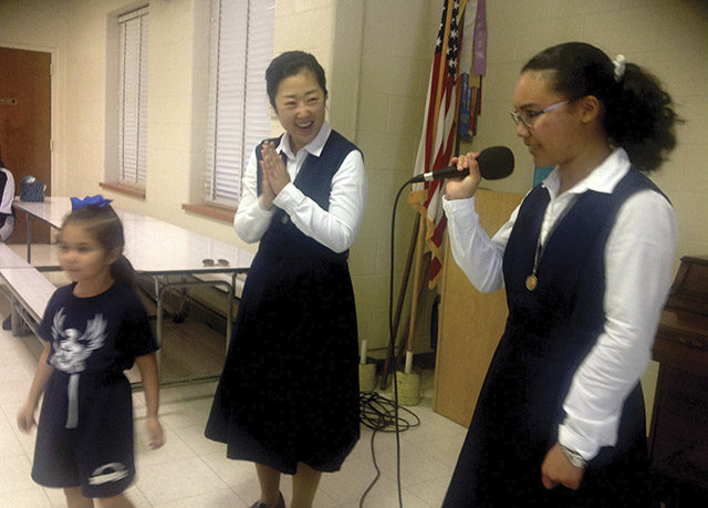 Lee with a student and a sister during a school presentation.