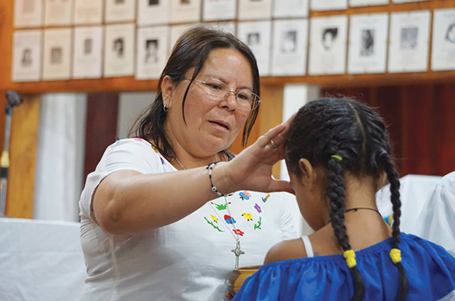 Sister Vilma Franco, S.P. blesses a girl during a Communion service. 